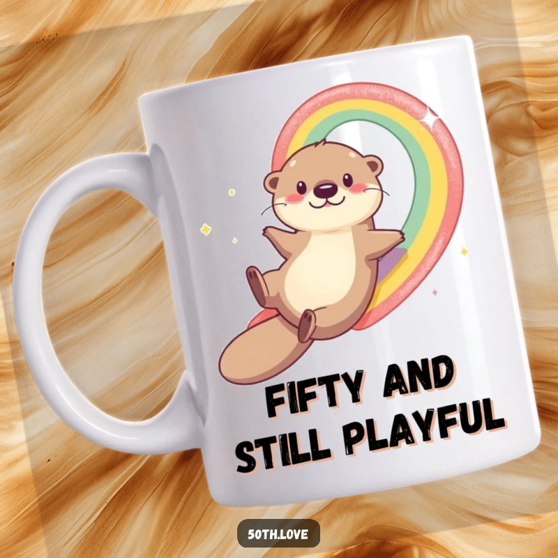 Funny otter sliding down a rainbow towards the number 50 on a mug, celebrating a joyous 50th birthday with playful energy.